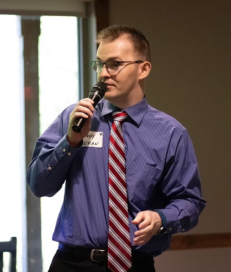 Brady speaking with a microphone