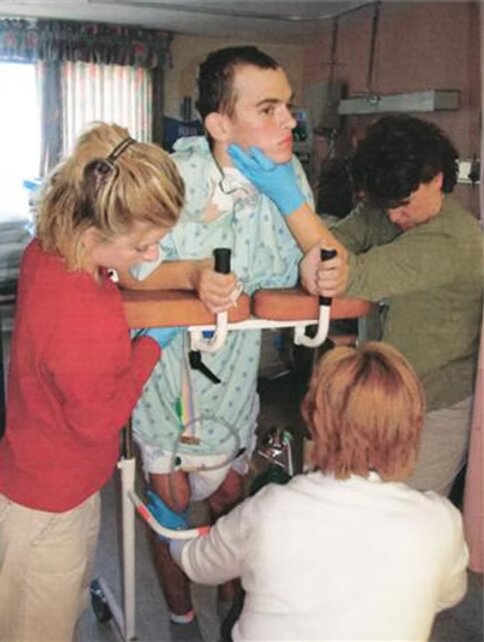 Brady learning to stand again with the help of therapists